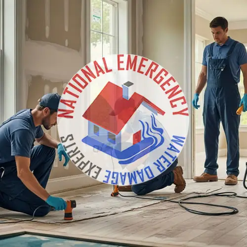 Two technicians from National Emergency Water Damage Experts working on water damage restoration in a residential setting, featuring tools and equipment for cleanup and repair.